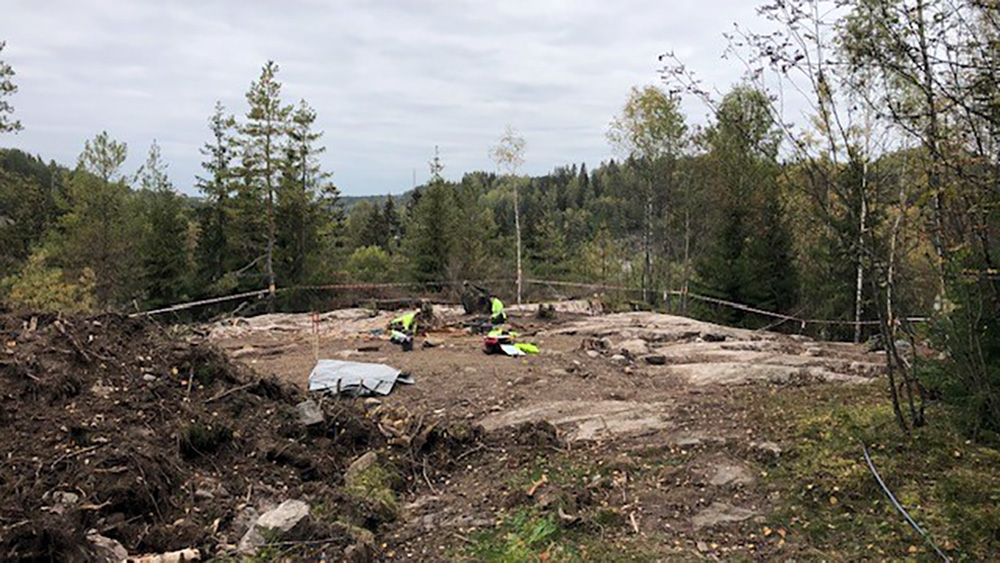 Excavation site in the forest with people working
